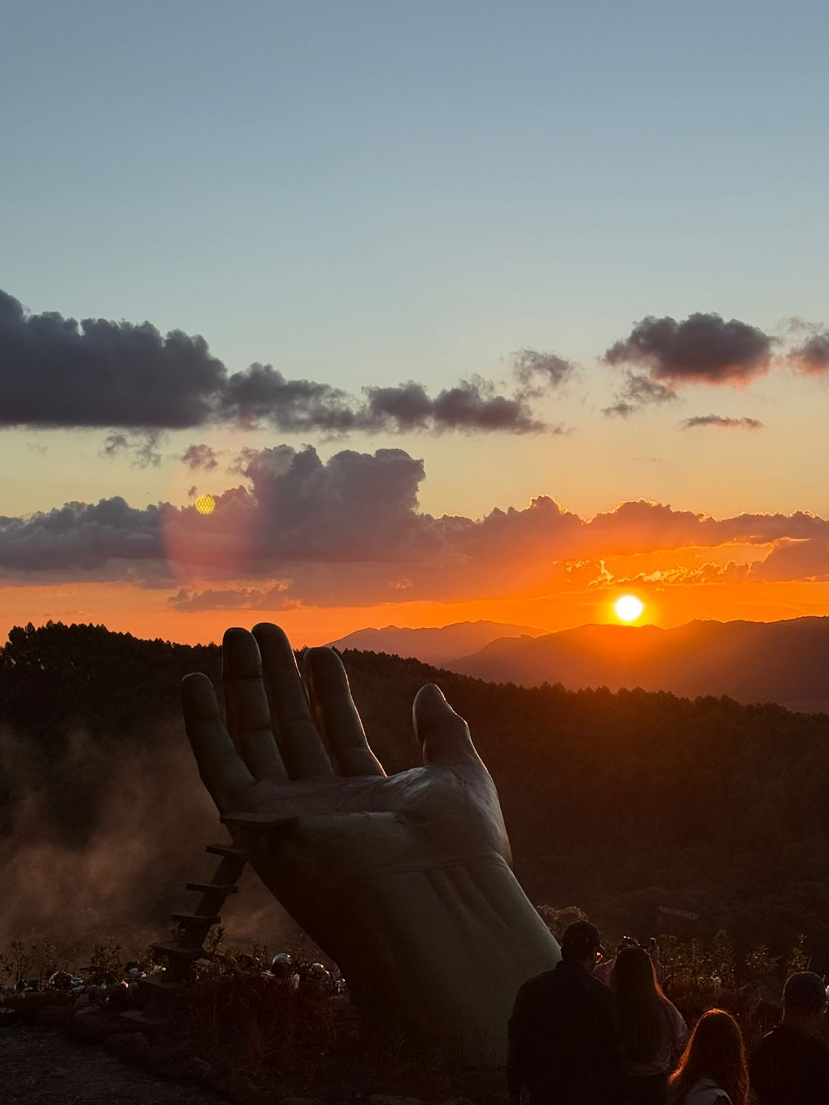 Mão erguida ao pôr do sol em passeio de quadriciclo em Monte Verde